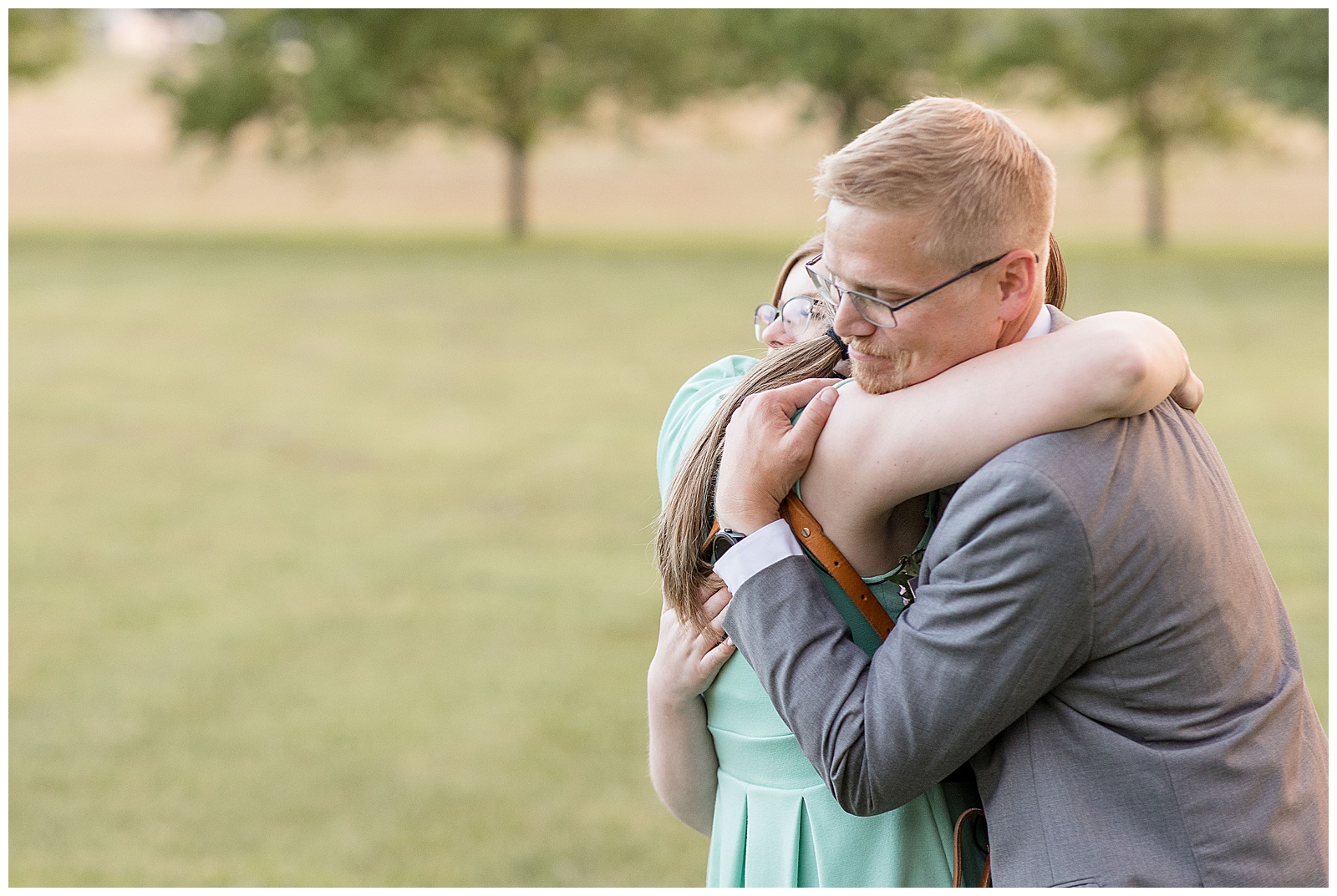 photographer hugging groom outside on lawn at the barn at silverstone in lancaster pennsylania
