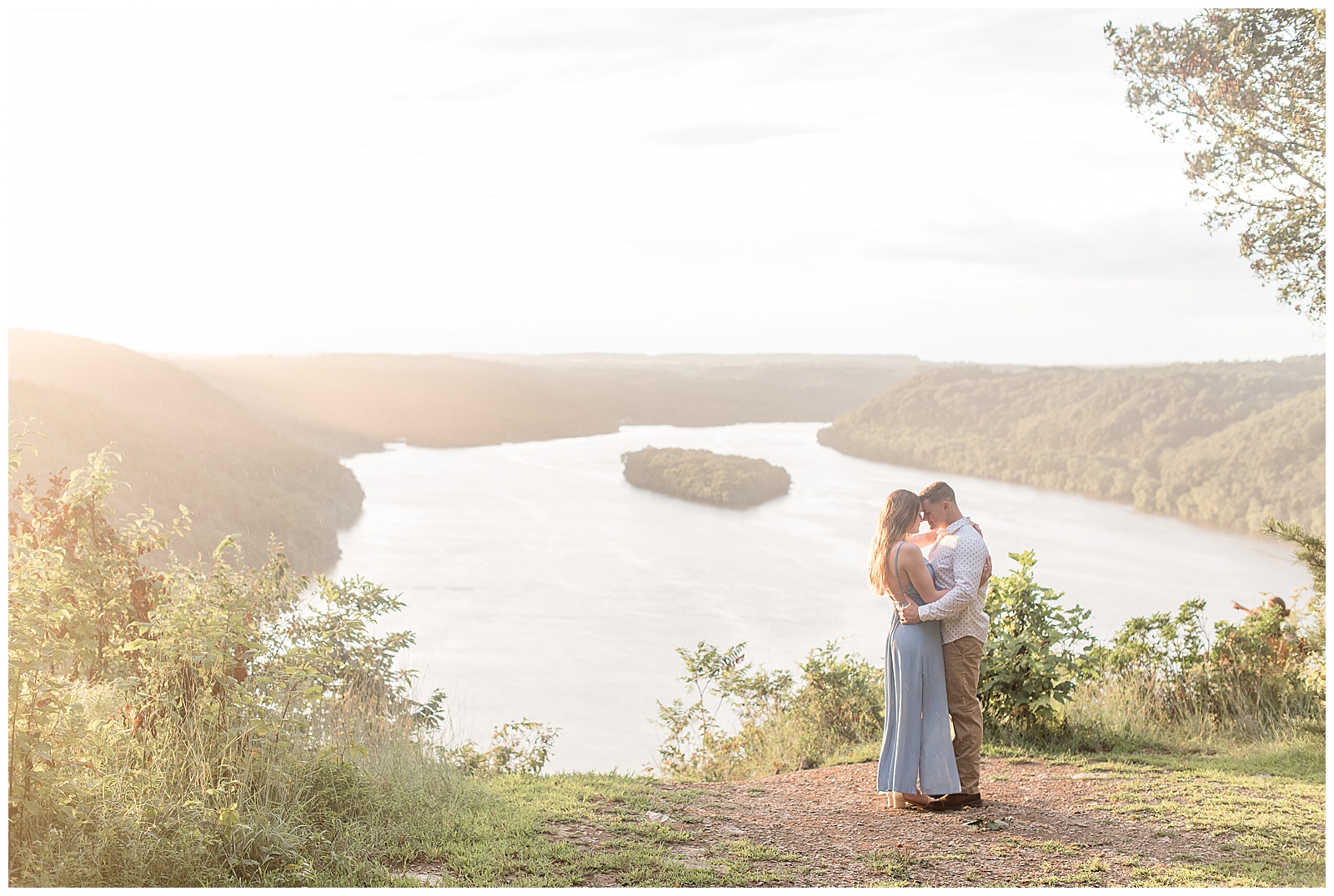 engaged couple hugging with foreheads touching on sunny evening at pinnacle point overlook with river behind them in holtwood pennsylvania