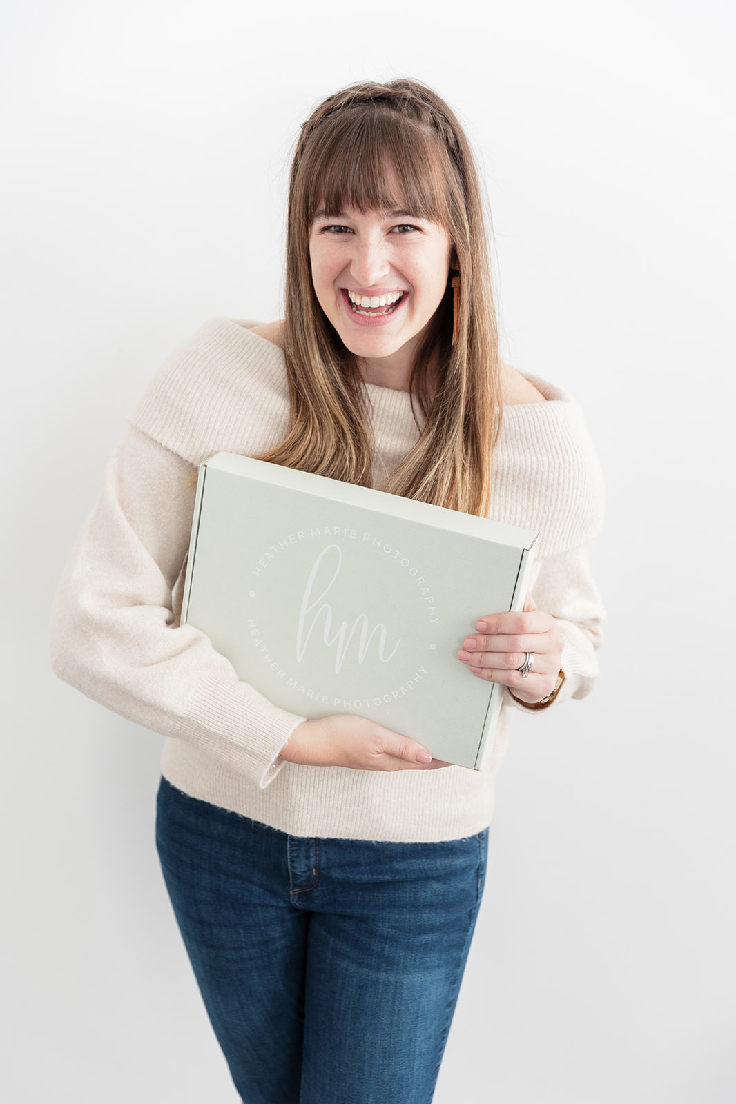 girl holding wedding welcome box gift and smiling at camera