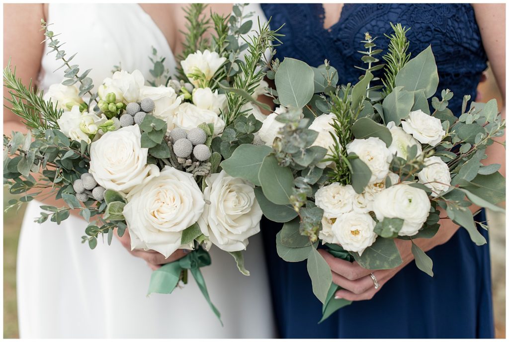 close up photo of bride and maid of honor holding their bouquets filled with white roses and eucalyptus in lancaster pennsylvania