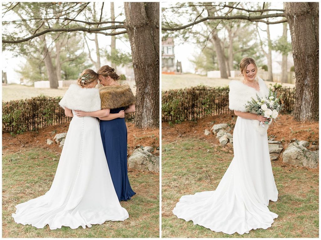 bride hugging her maid of honor with their foreheads touching and their backs toward camera under evergreen tree