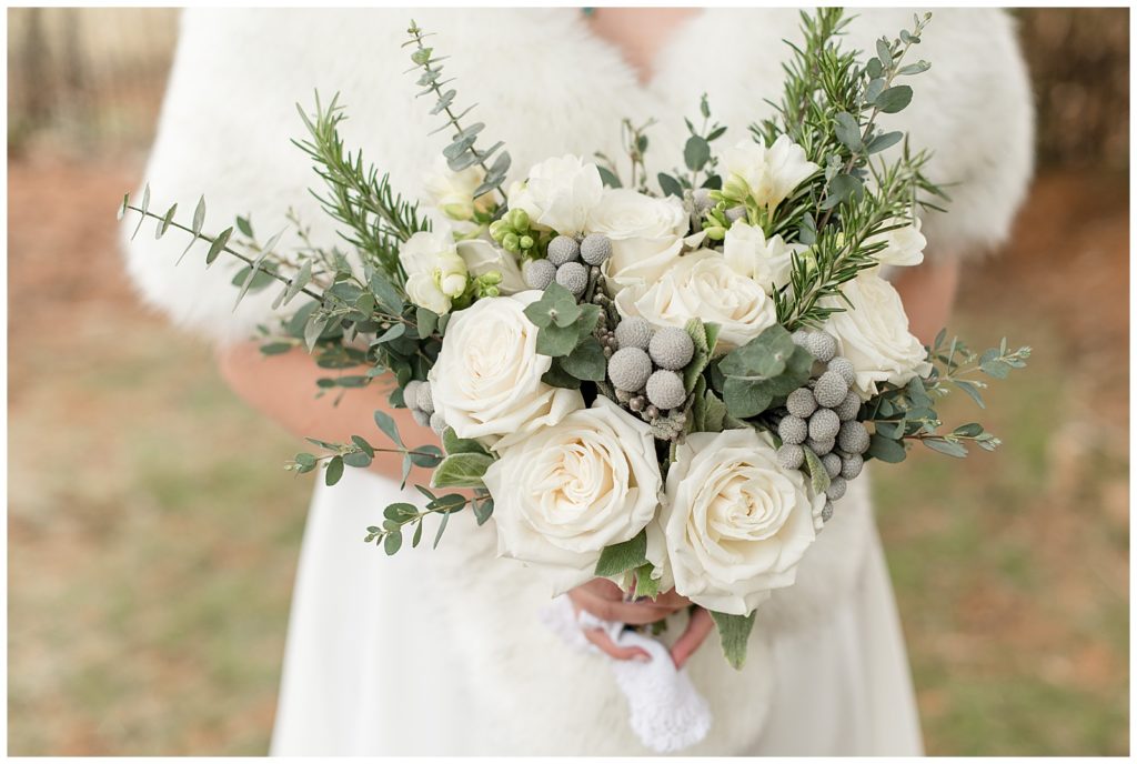 close up photo of stunning bridal bouquet filled with white roses, eucalyptus, and other greenery in lititz pennsylvania