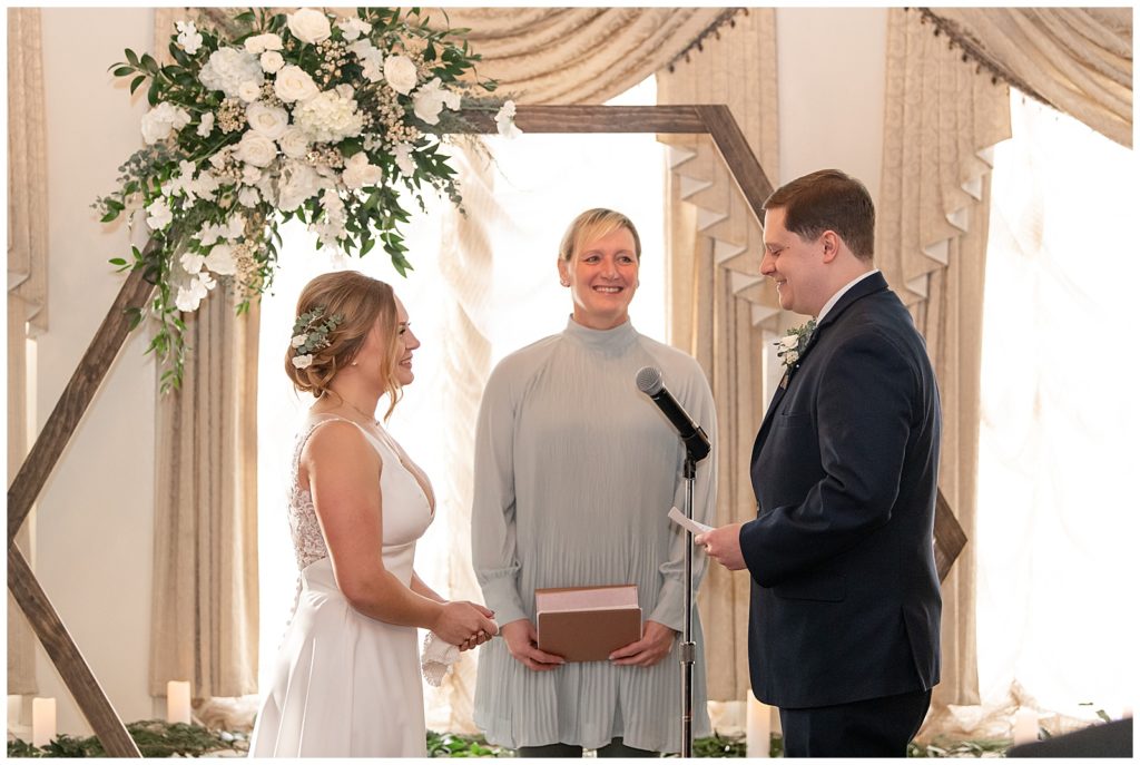 groom sharing his vows with his bride during wedding ceremony with officiant between them at the lititz springs inn and spa
