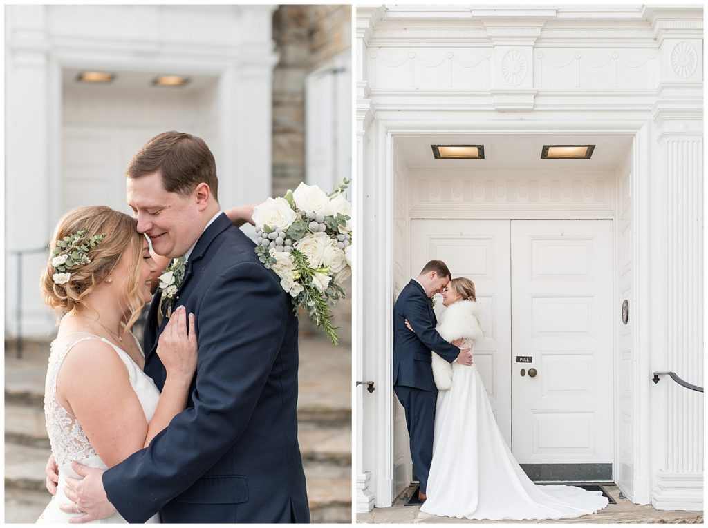 bride and groom hugging tightly by white doors of historic stone building with their foreheads touching