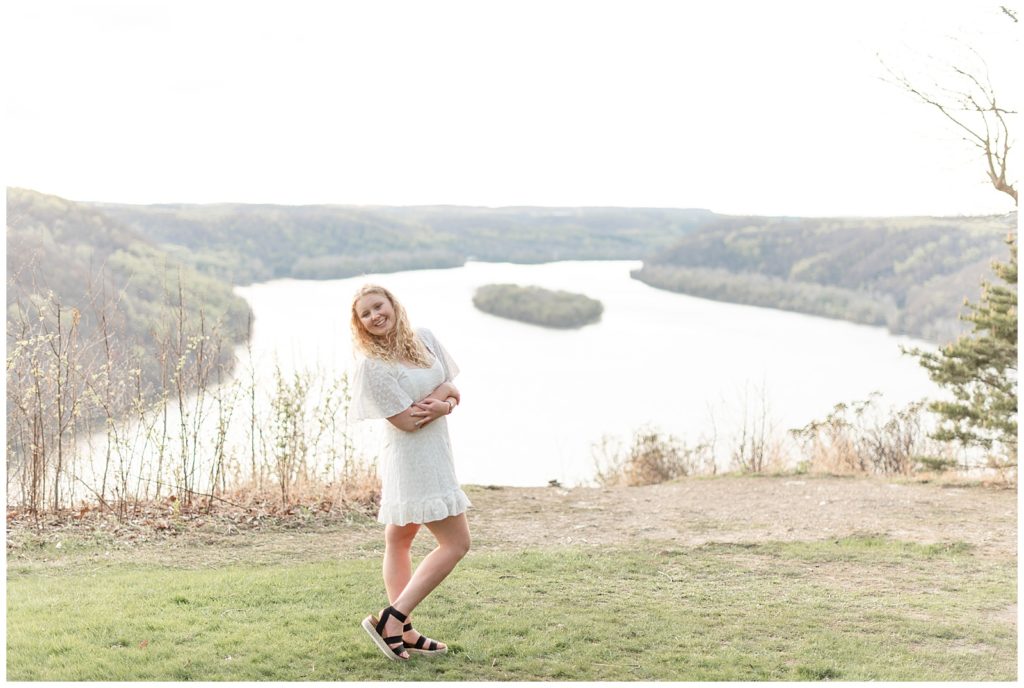 senior girl in short white dress with right knee popped by pinnacle point overlook in lancaster pennsylvania