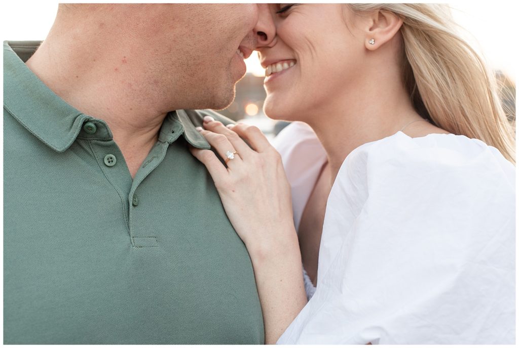 close up photo of engaged couple almost kissing as woman shows off her diamond engagement ring on guy's shoulder in annapolis maryland