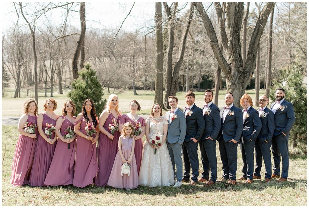 couple surrounded by their bridal party on sunny spring day at stock's manor in mechanicsburg, pennsylvania