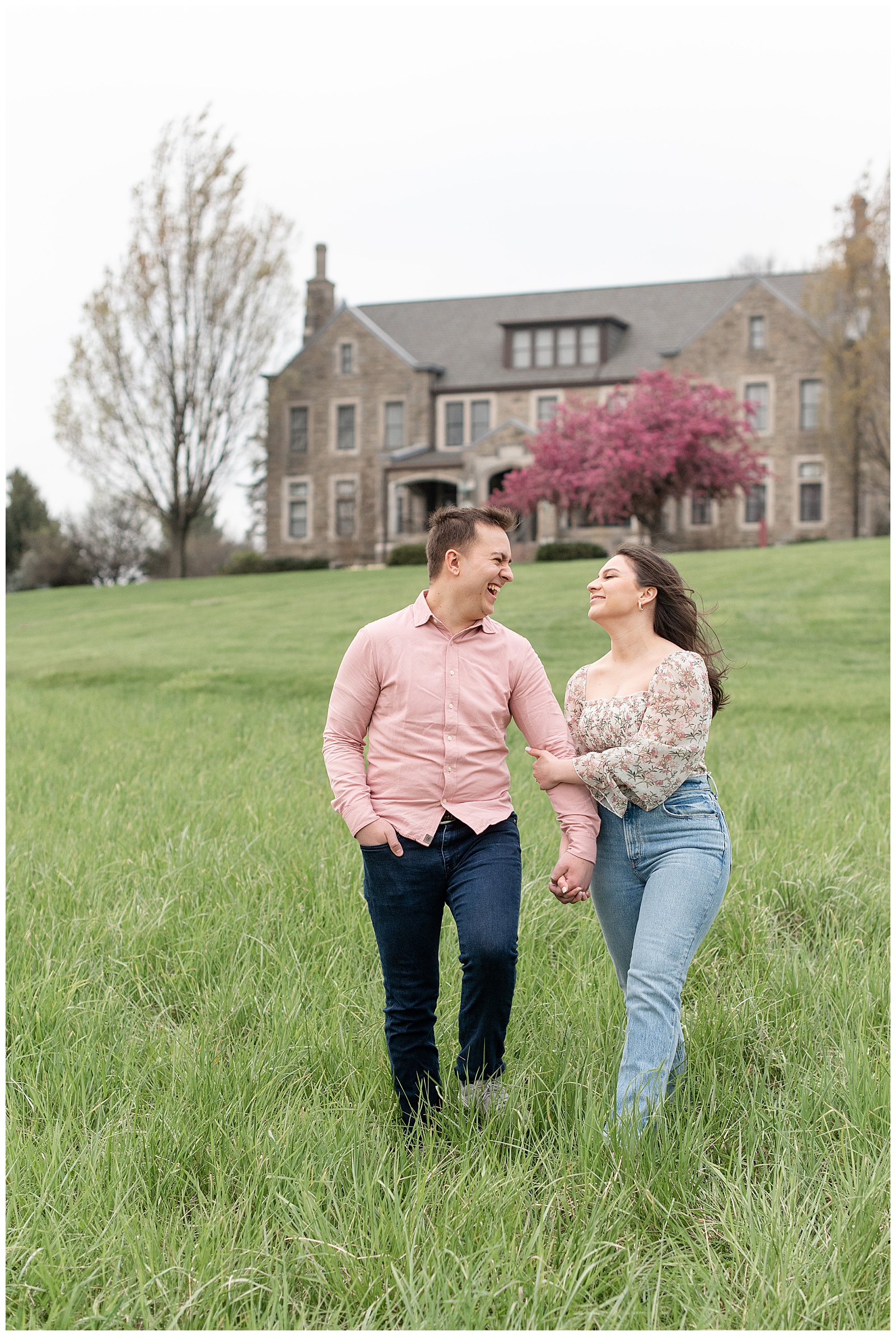 engaged couple holding hands looking at each other smiling and walking towards camera in lancaster pennsylvania