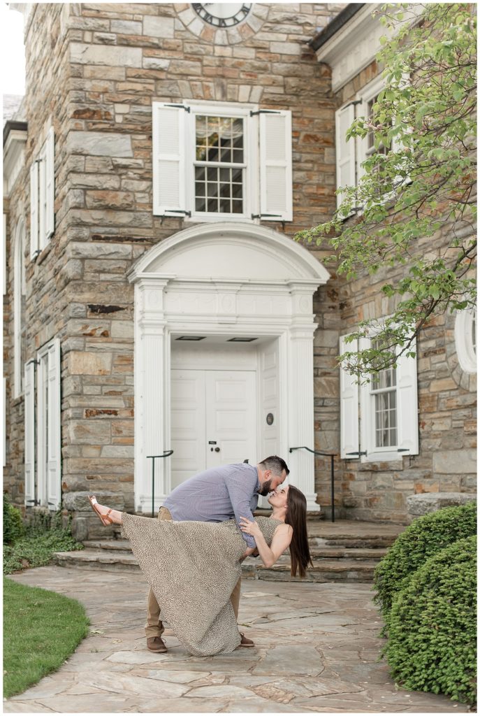 guy dipping girl back as they're almost kissing in front of historic stone building in downtown lititz