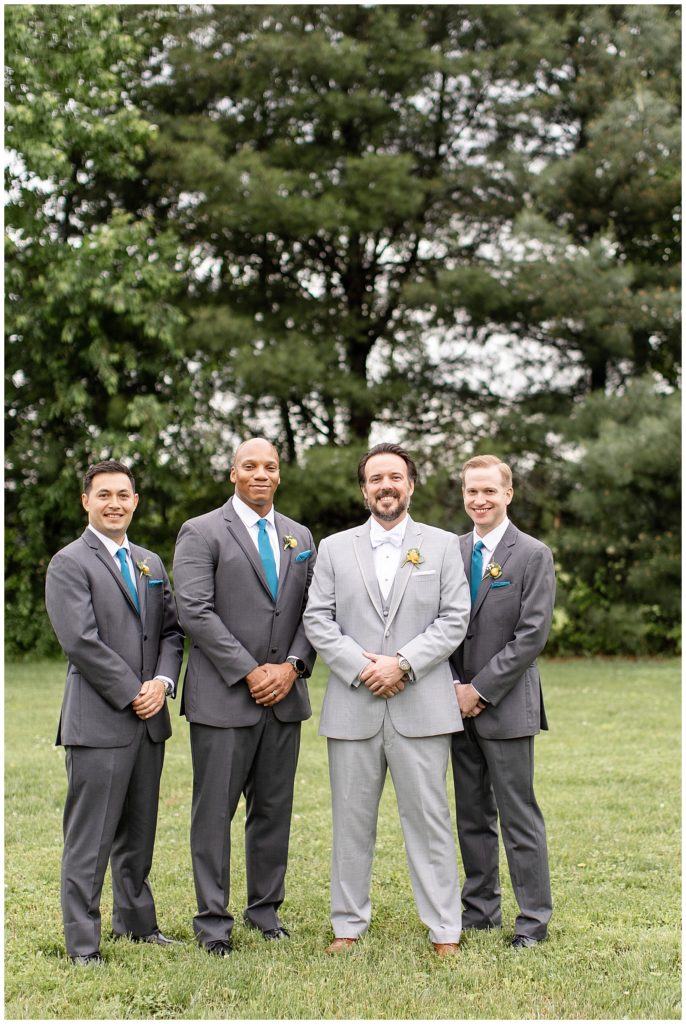 groom with this three groomsmen all wearing gray suits with groom in lighter gray suit in lancaster pa