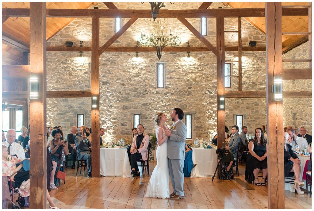 bride and groom sharing their first dance during beautiful stone barn reception at the barn at silverstone