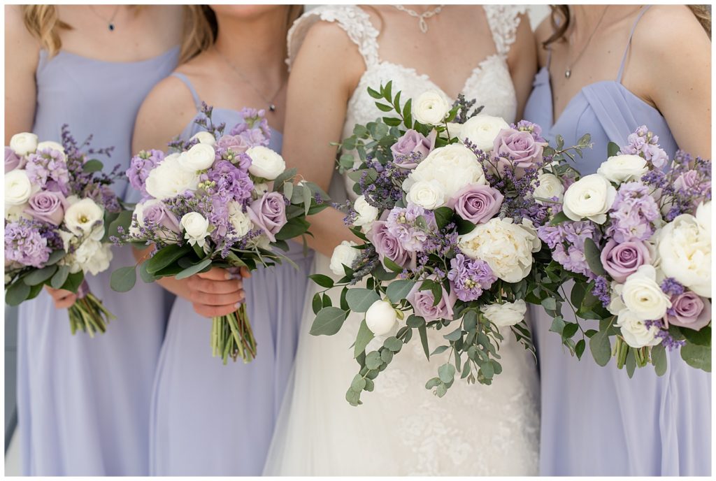 close up of the bride's and bridesmaids' purple and white rose bouquets at melhorn manor