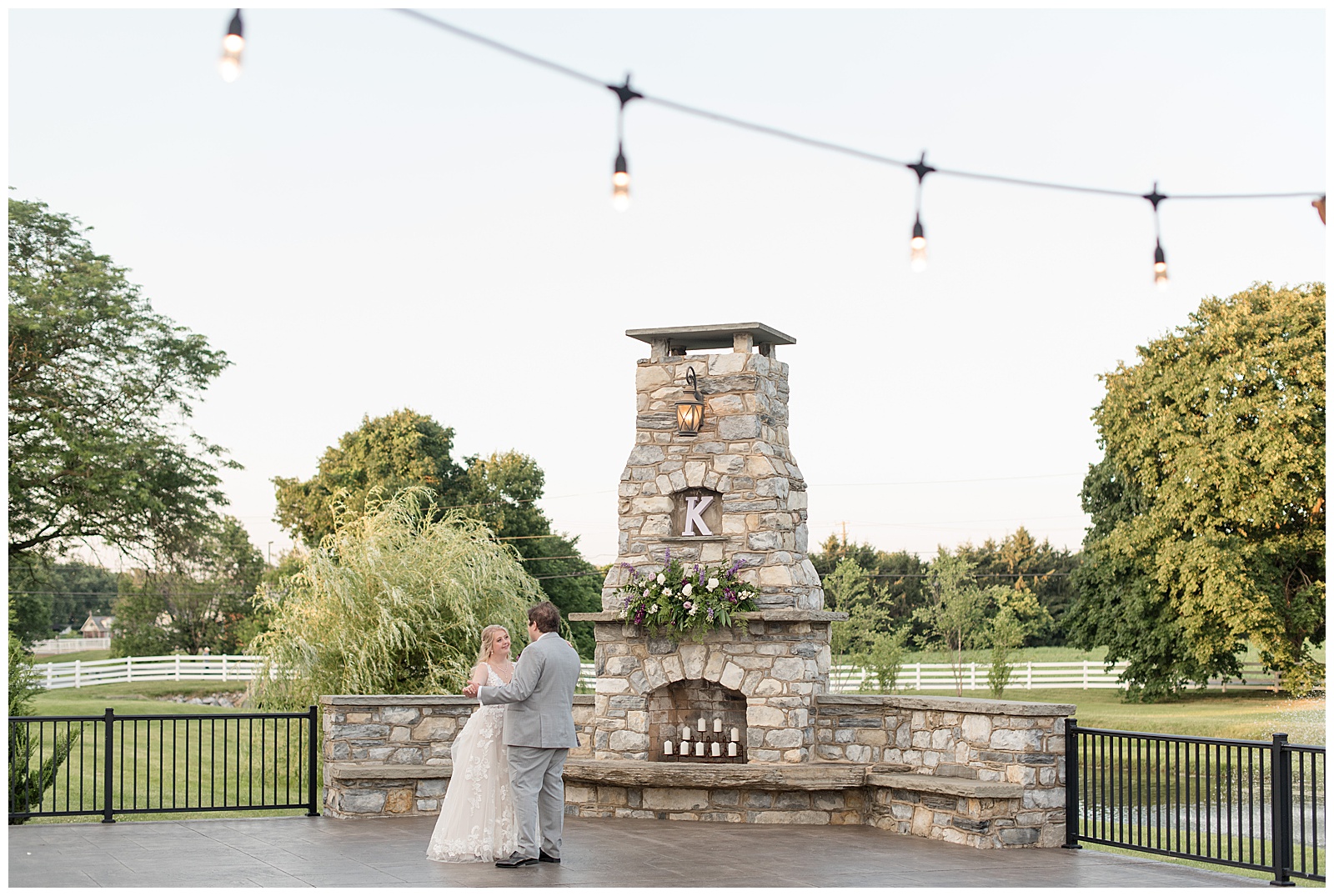 bride and groom slow dancing on patio at the Barn at Silverstone in front of stone fireplace