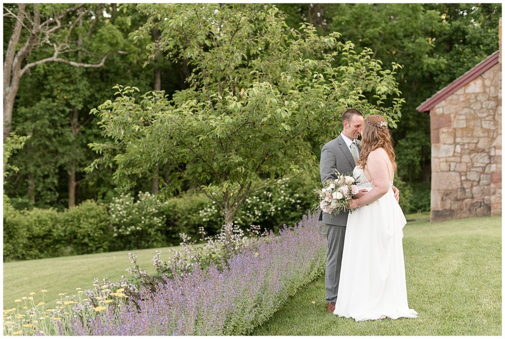 bride and groom kissing by row of lavender at elizabeth furnace