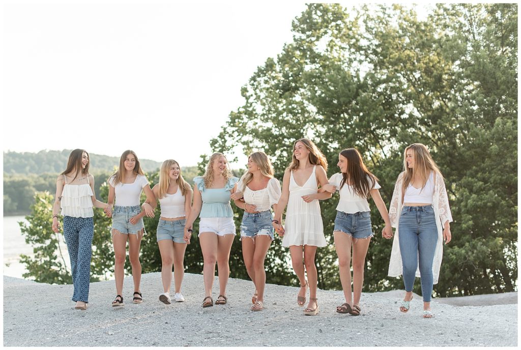senior girls with arms linked walking towards camera on sunny evening at the white cliffs of conoy