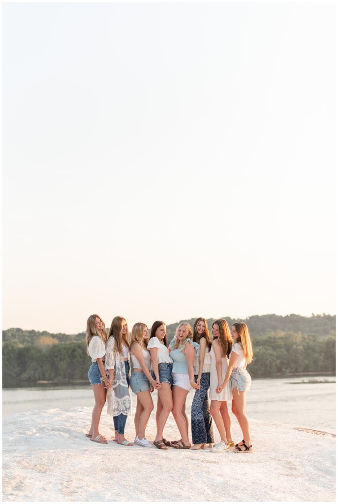 eight senior girls standing close together and smiling atop the white cliffs of conoy in lancaster, pennsylvania