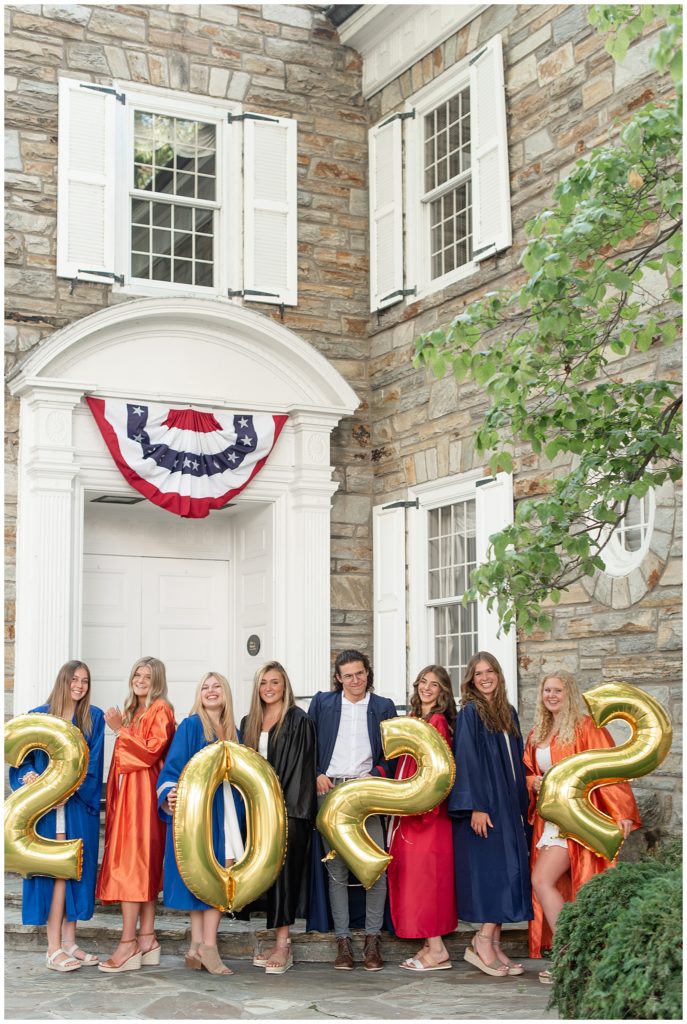eight senior spokesmodels posing in their colorful graduation gowns and holding 2022 balloons in lititz pennsylvania