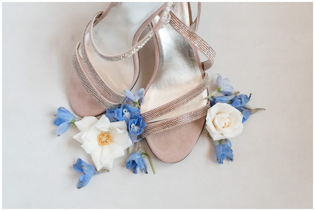bride's tan strappy sandals surrounded by blue and white flowers in montgomery county pennsylvania