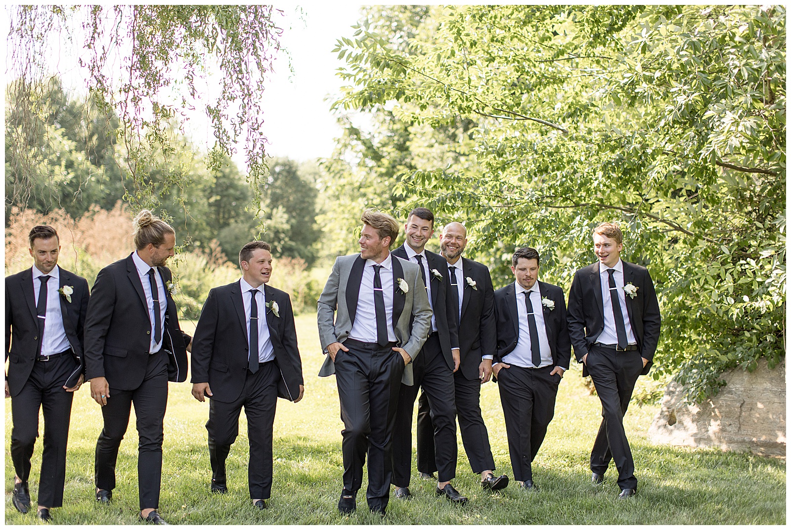groom walking towards camera with his hands in his pockets along with his groomsmen in lancaster county