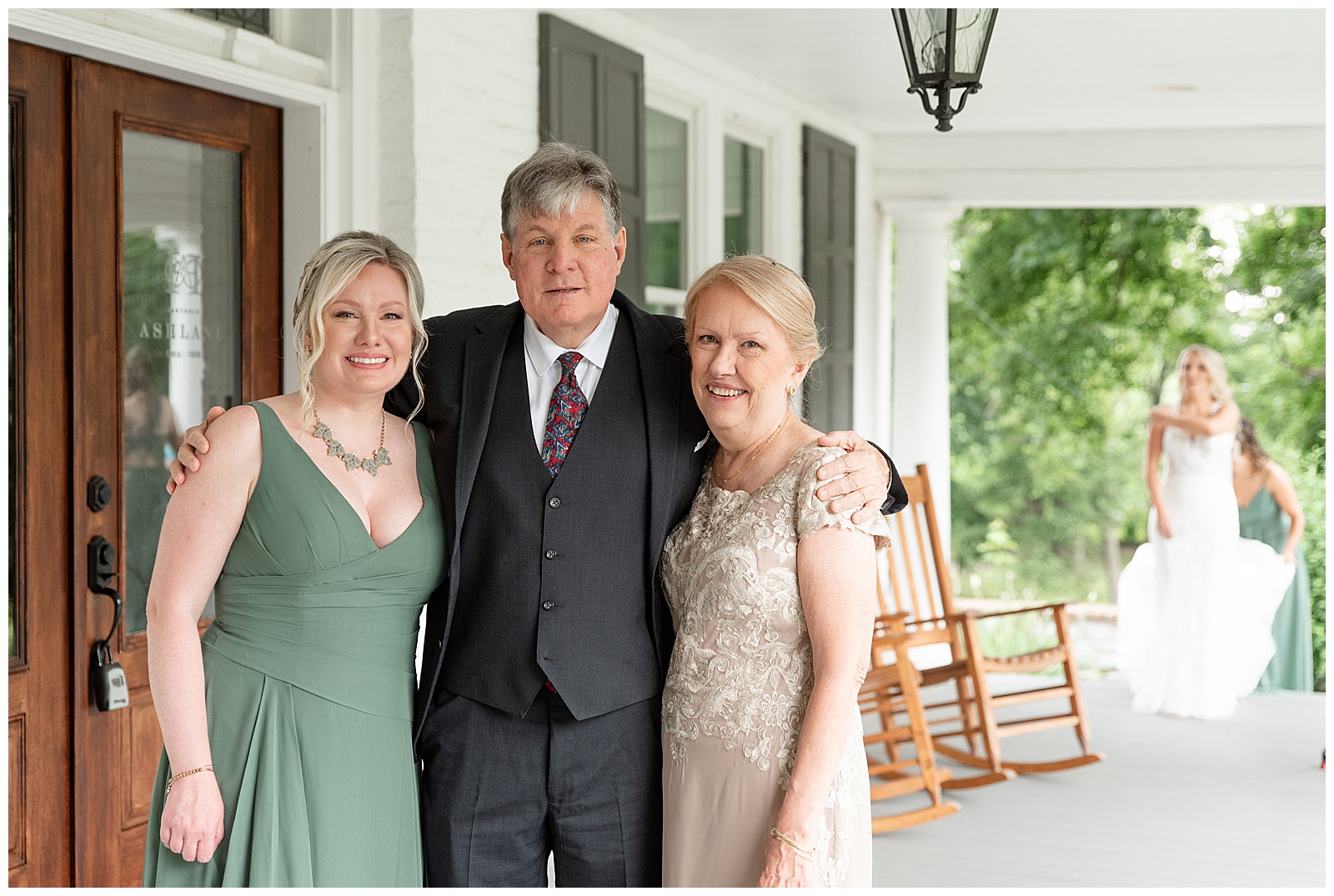bride's parents and sister standing on front porch of farmhouse and smiling at camera at historic ashland