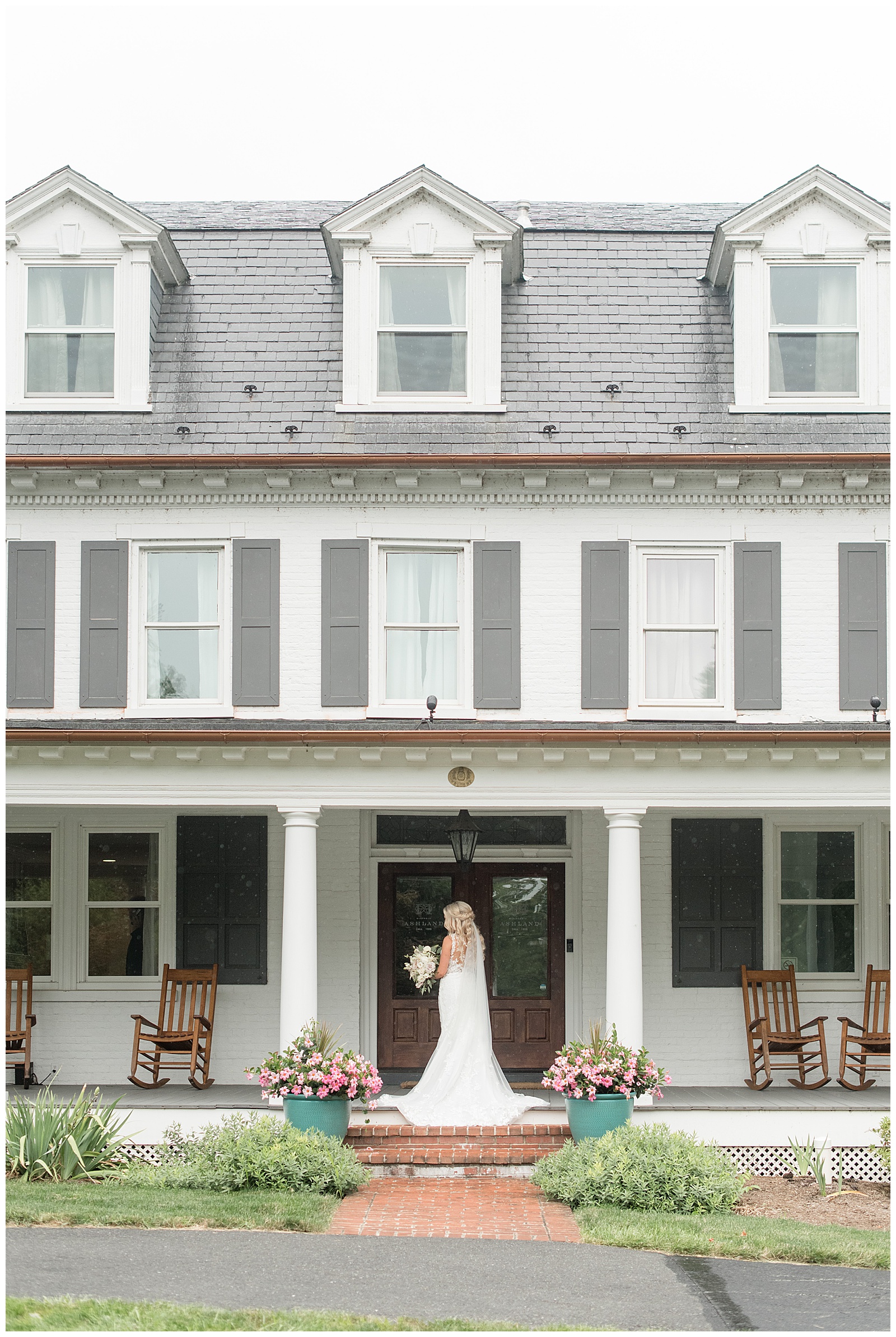 bride standing on front porch of farmhouse with her back towards camera and her dress train displayed at historic ashland