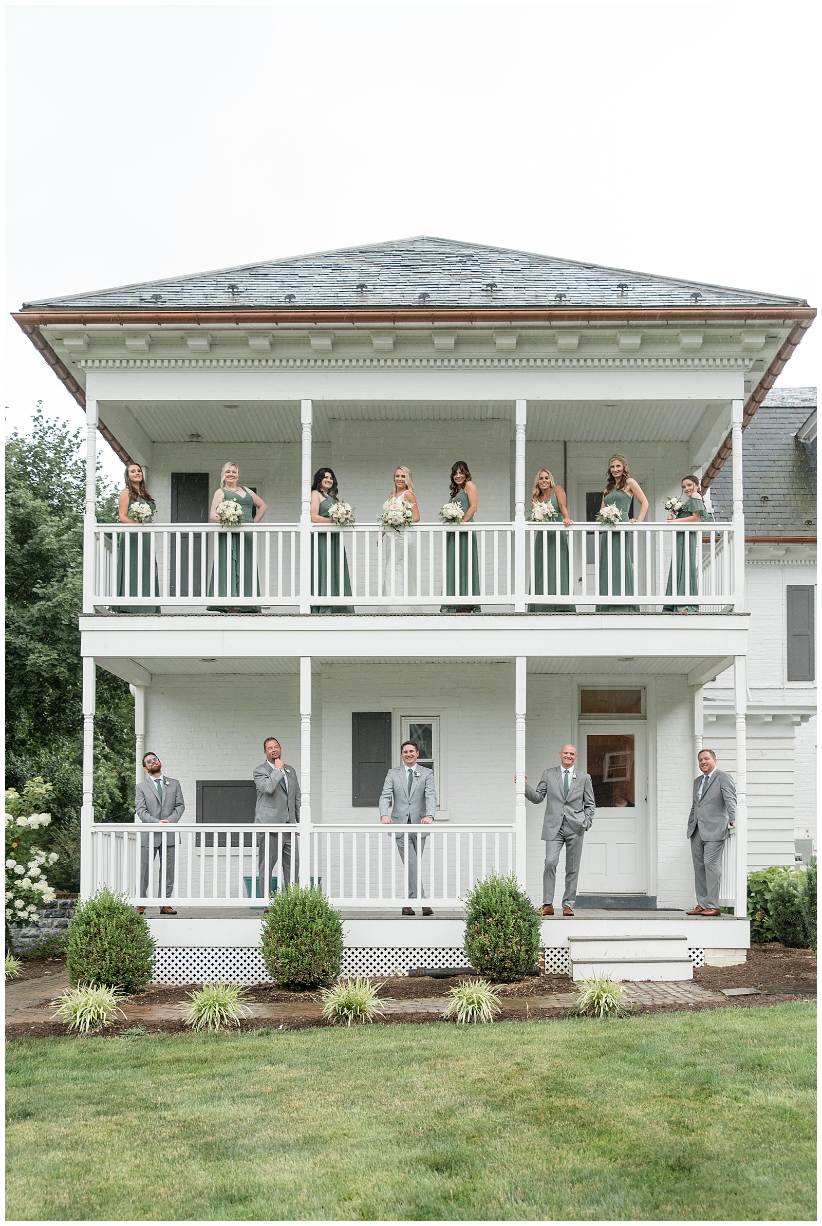 bridesmaids on upper porch and groomsmen on lower porch of white farmhouse deck at historic ashland in york county