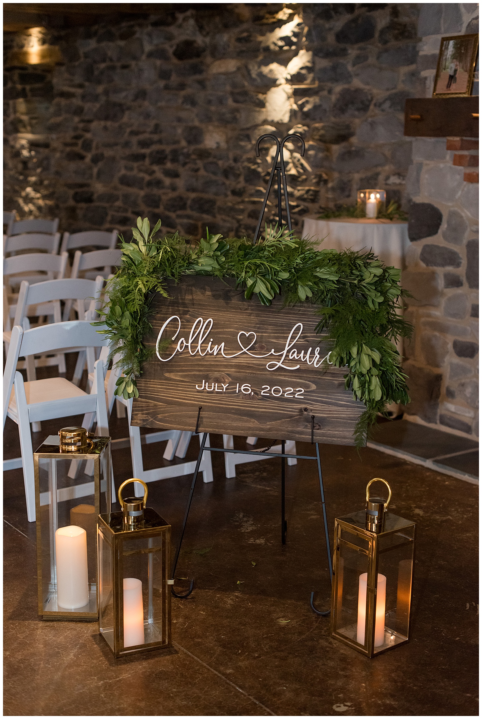 wooden sign with couples' names displayed with greenery by rows of white chairs for wedding ceremony at historic ashland