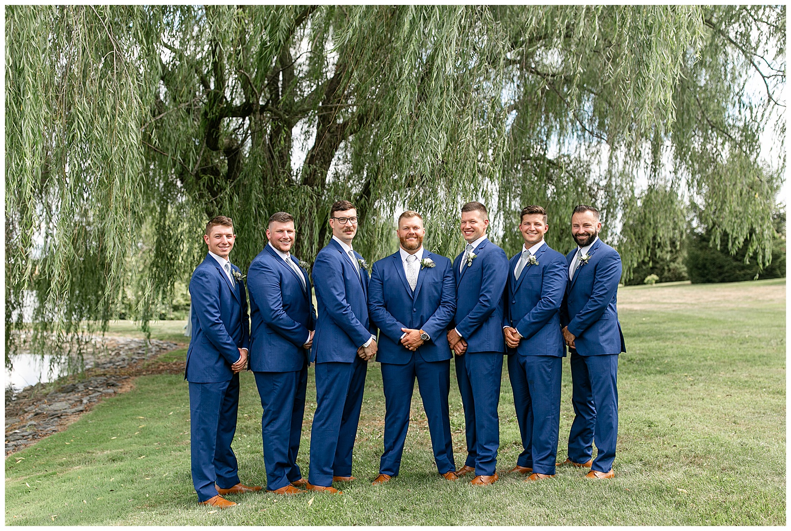 groom standing with his six groomsmen all in blue suits by willow tree in manheim pennsylvania