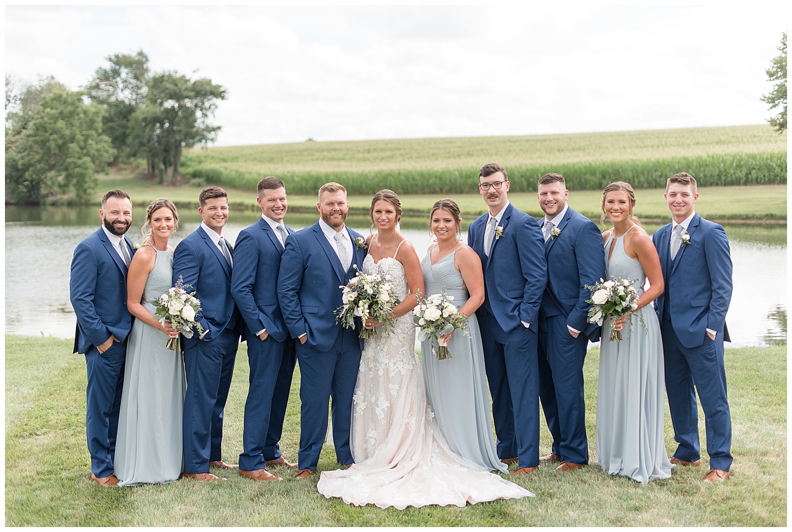 bride and groom surrounded by bridal party on sunny day by pond in manheim pennsylvania