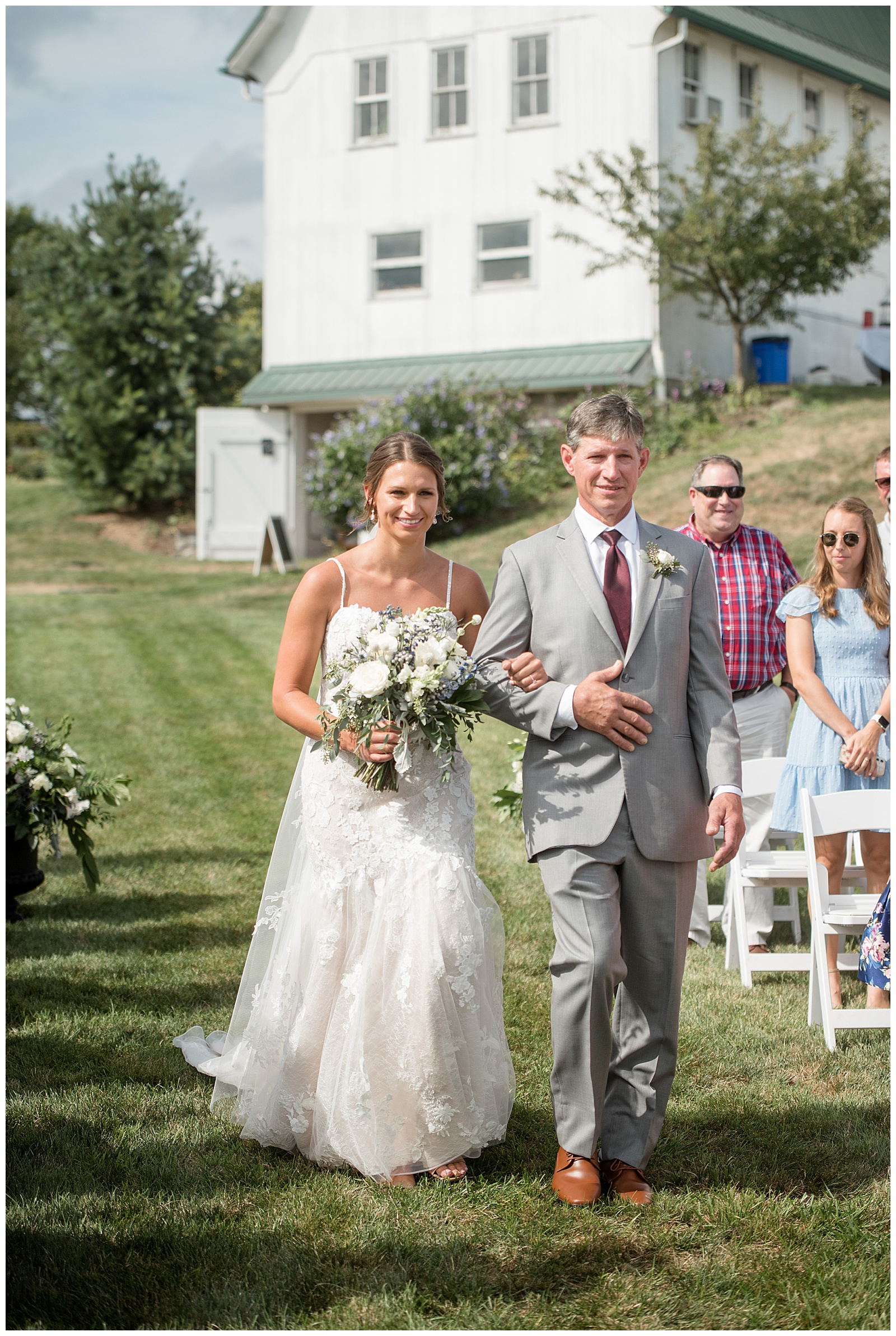 bride being walked down the aisle by her father on sunny summer day at lakefield weddings in manheim pennsylvania