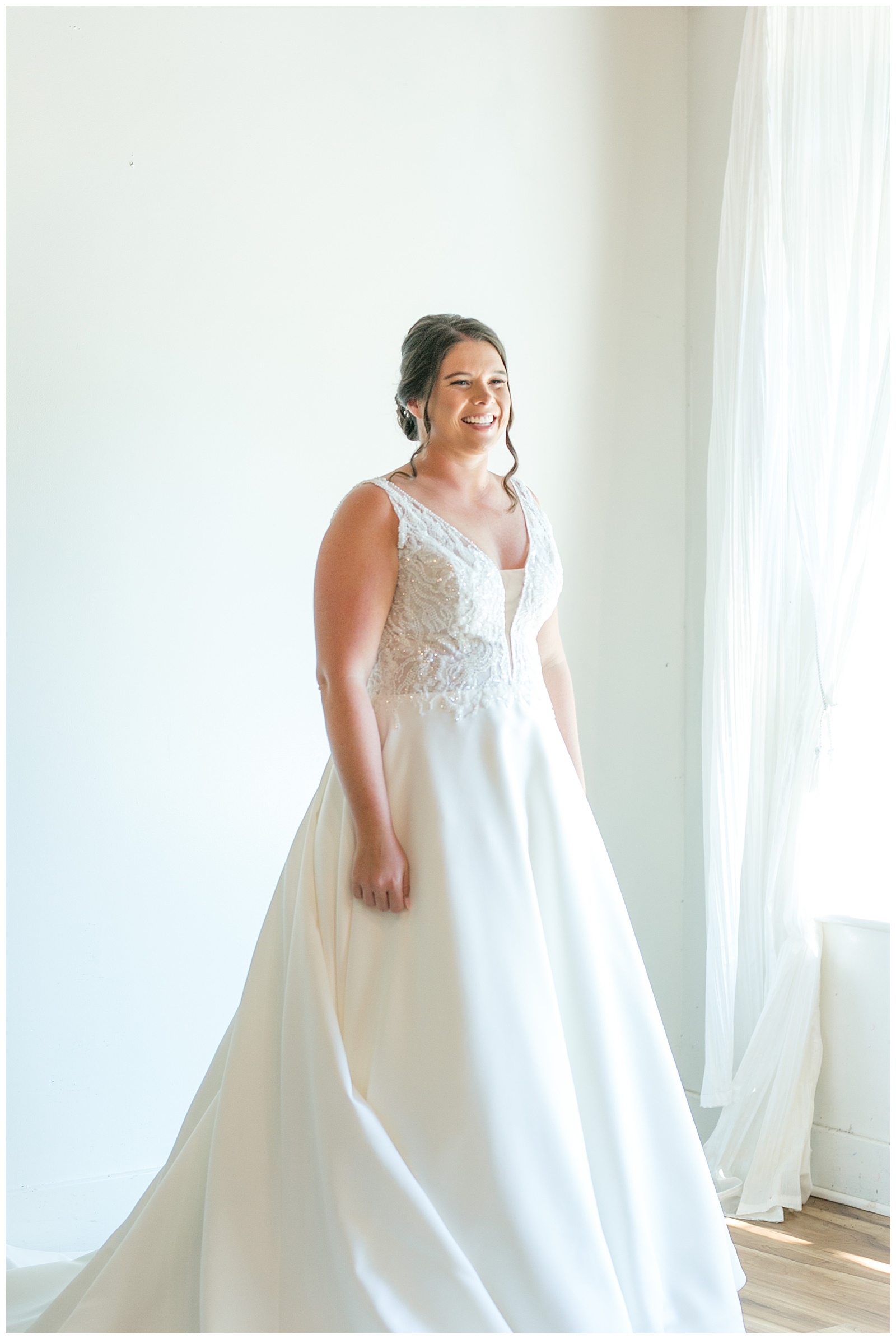 bride in sleeveless v-neck white gown in white bridal suite at the manor at mountain view