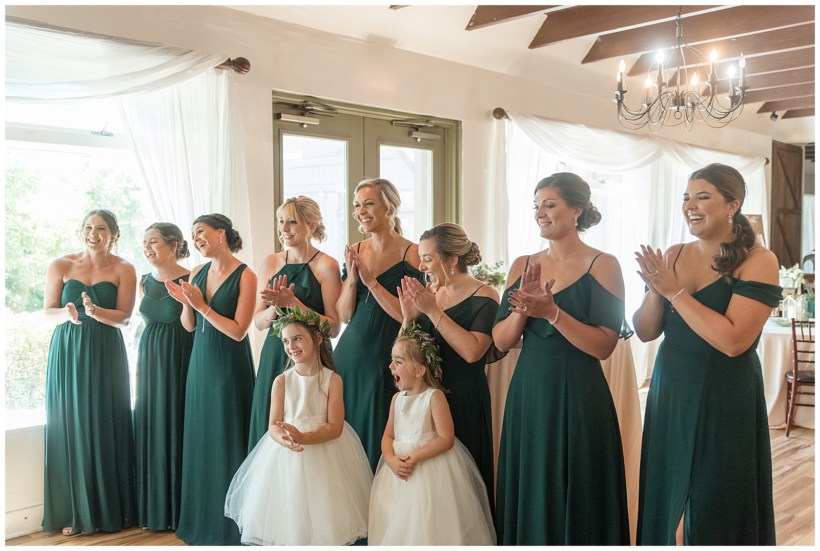 bridesmaids in dark green gowns and two flower girls in white dresses all seeing the bride in her gown in harrisburg pennsylvania