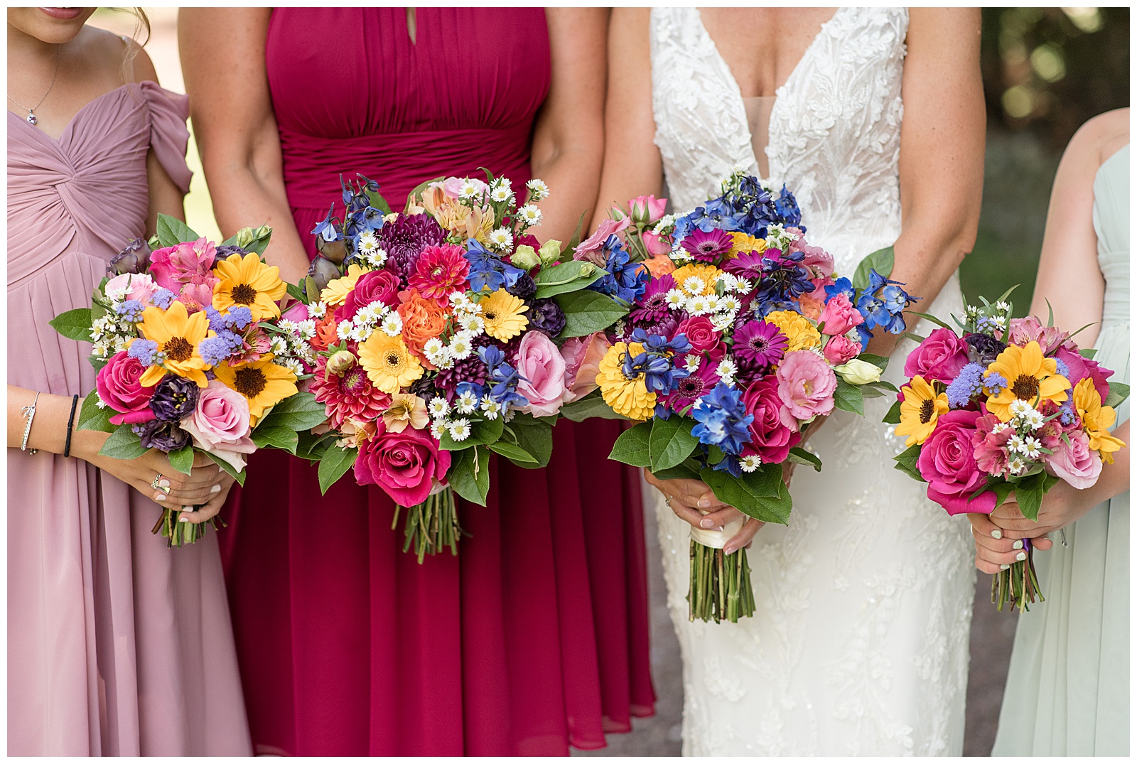 close up of bride and bridesmaids all holding vibrant flower bouquets at the inn at leola village