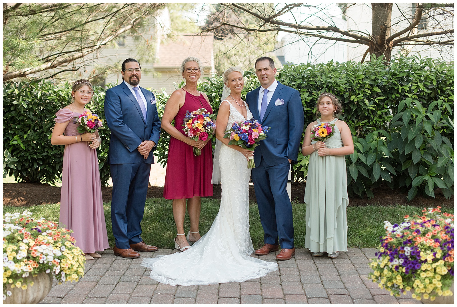 couple surrounded by their bridal party on brick patio at the inn at leola village in leola pennsylvania