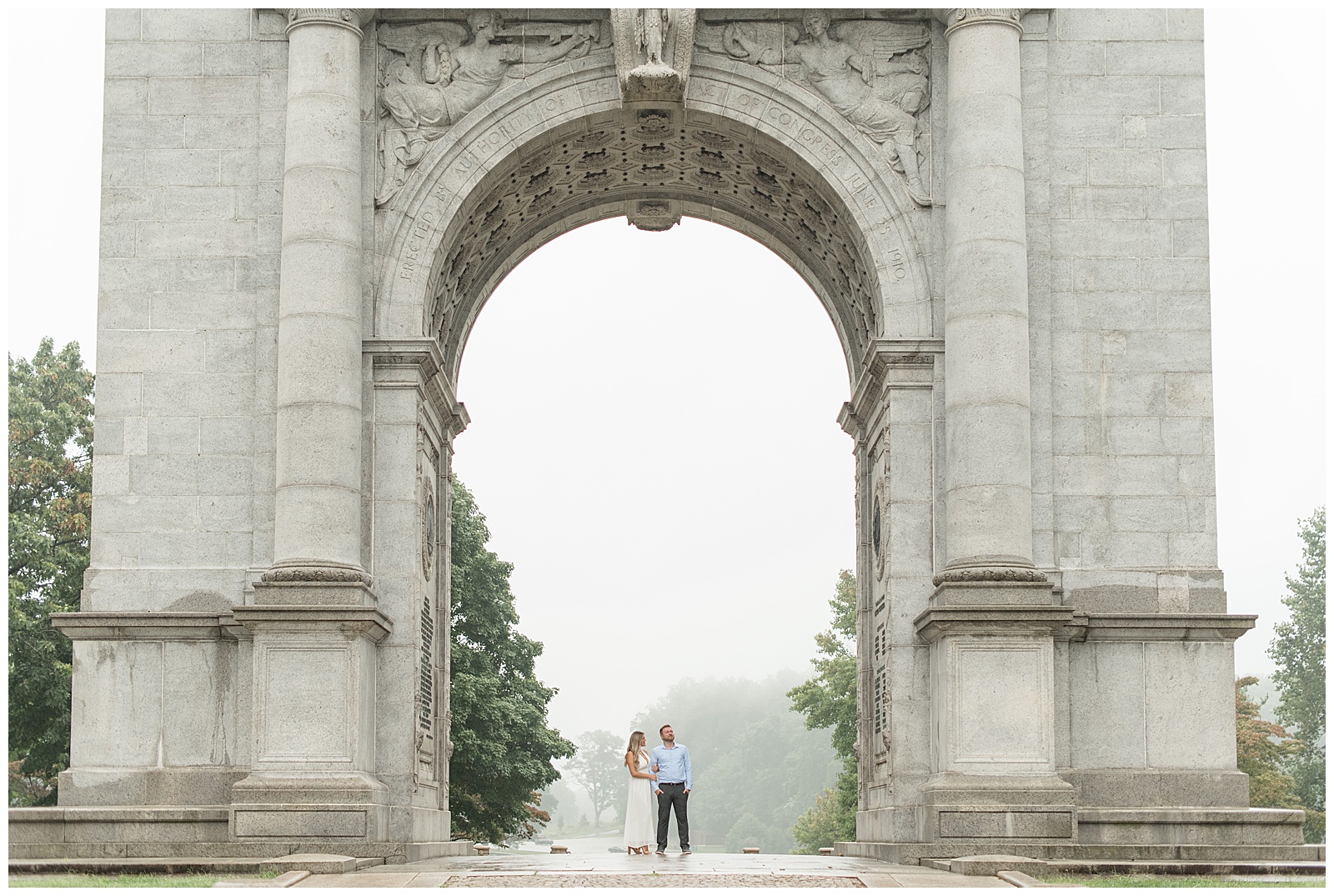 couple standing under huge archway on foggy day at national memorial arch in valley forge national park