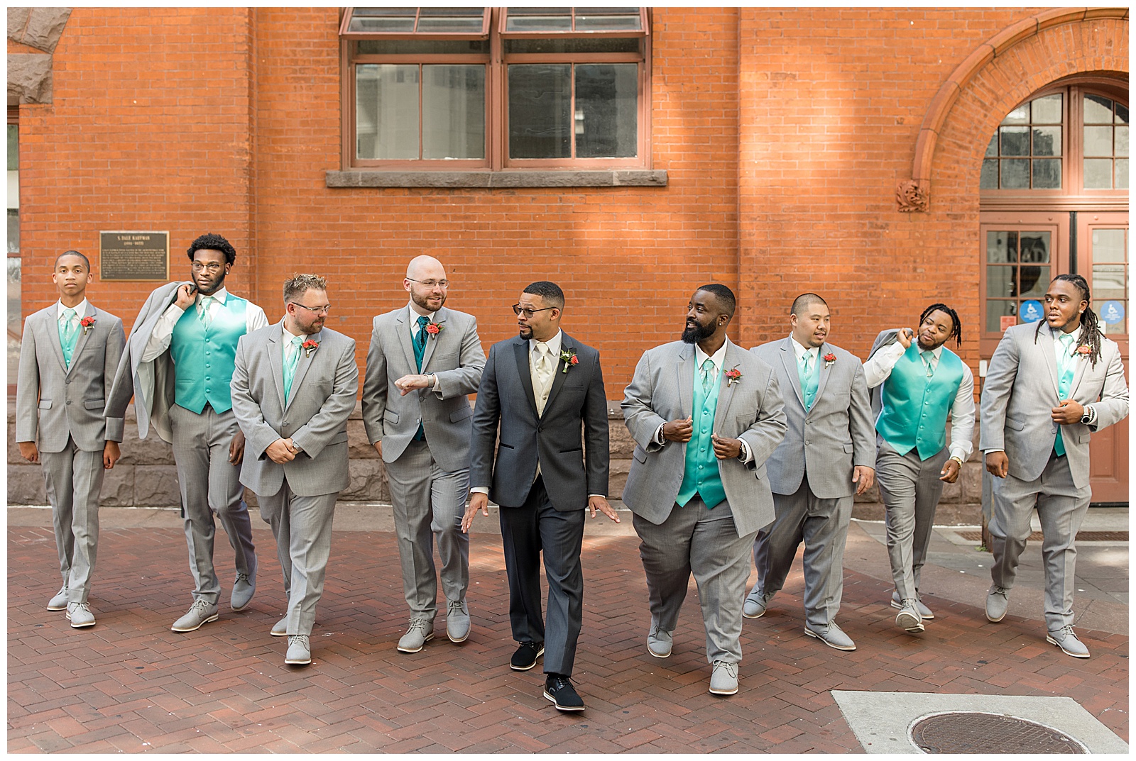 groom and his groomsmen casually walking towards the camera and smiling at each other by central market in lancaster pennsylvania
