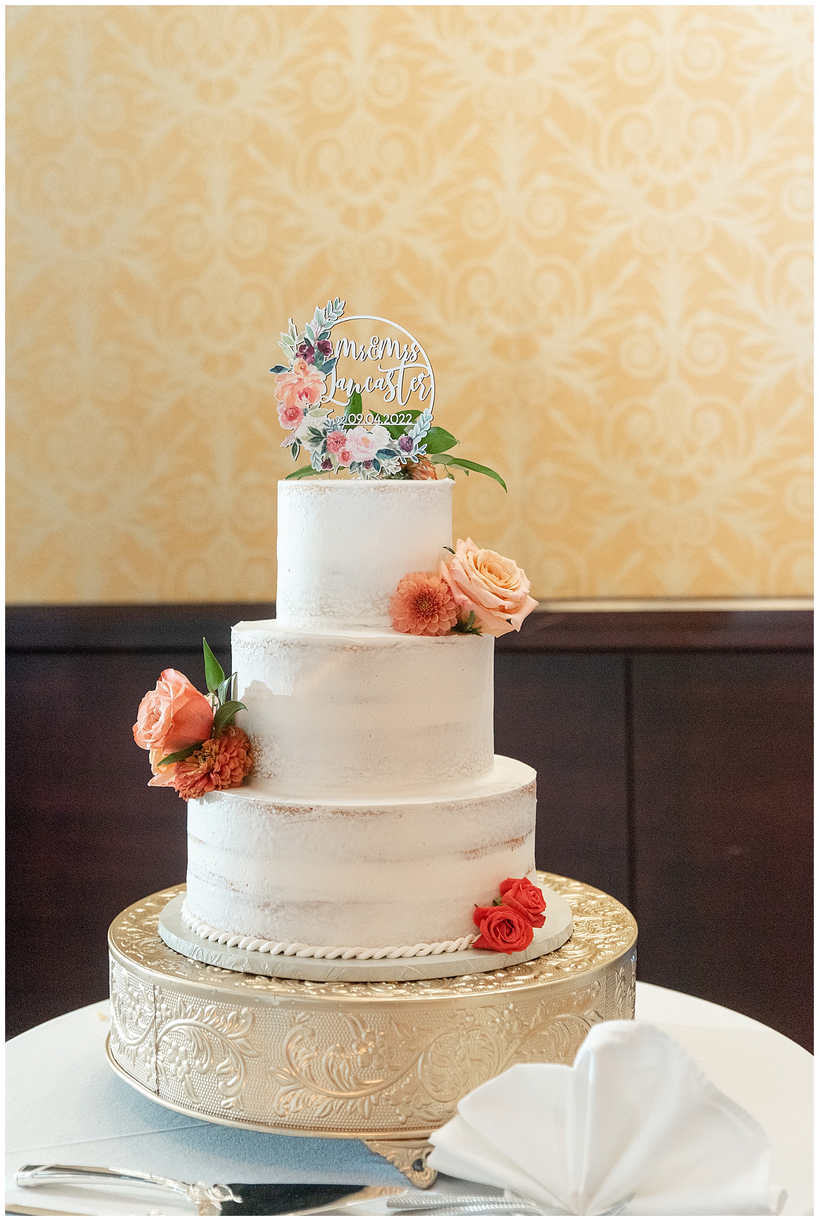 beautiful three tiered white wedding cake with colorful flowers and a floral cake topper at the lancaster marriott in lancaster pa
