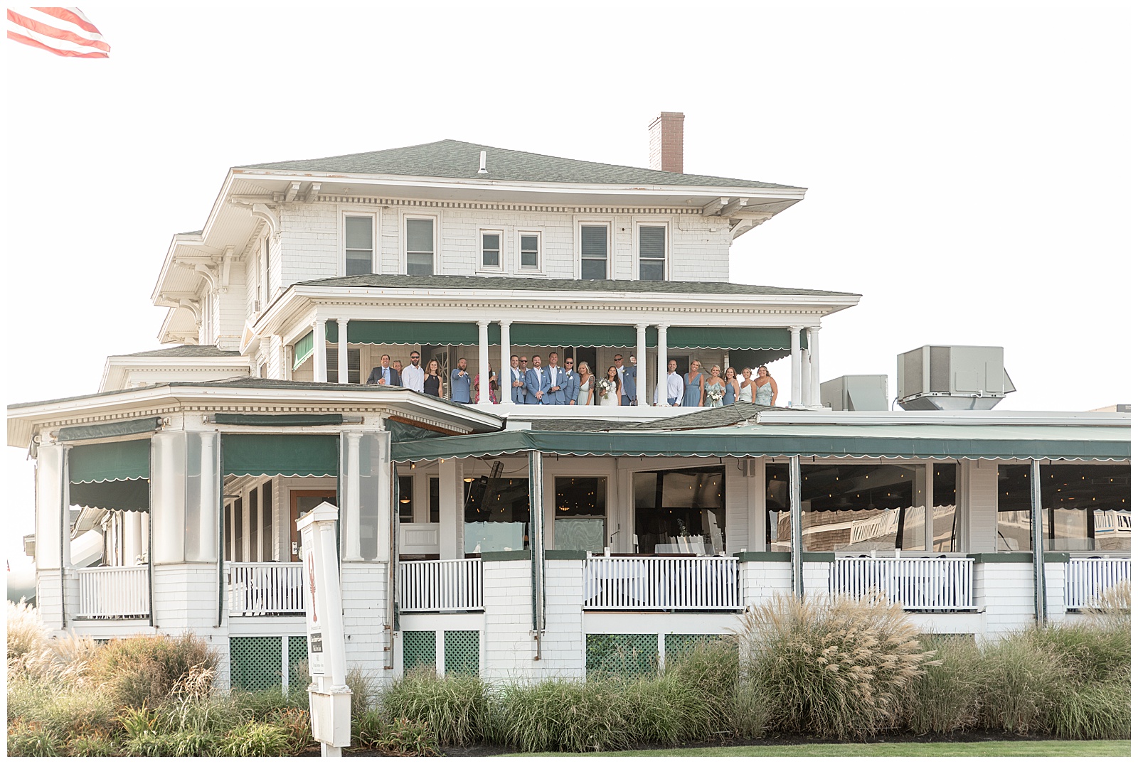 bridal party all on second story balcony of white beach house in new jersey