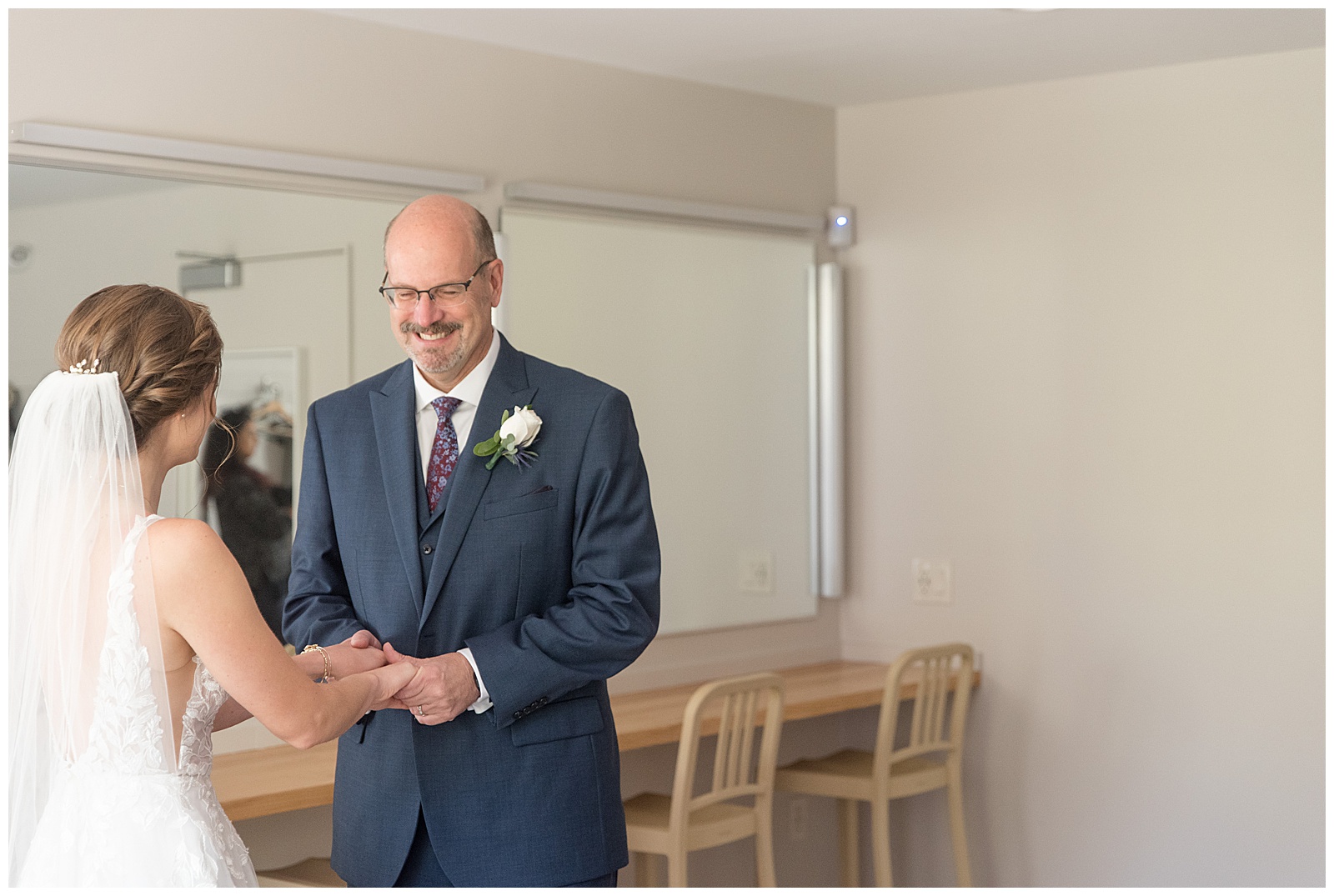 bride and her father sharing a first look moment in bridal suite as he smiles big in lititz pennsylvania