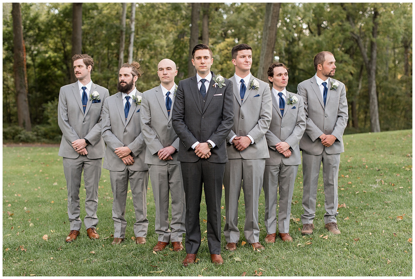 groom wearing dark gray suit with his six groomsmen lined up in a v behind him in light gray suits in lancaster pa