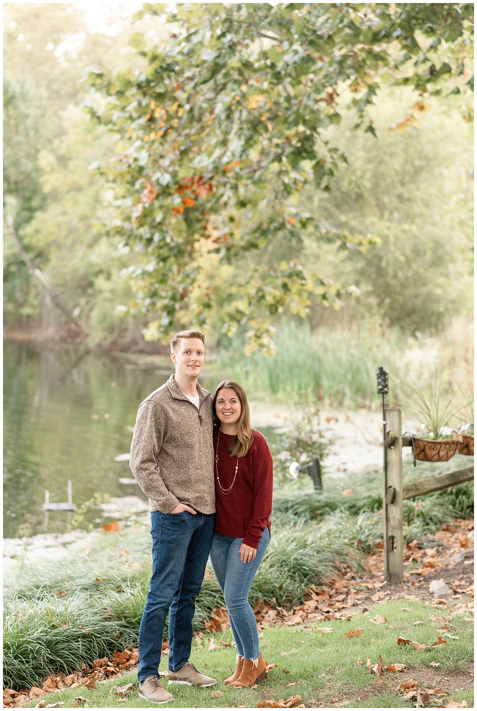 engaged couple standing with arms around each other by beautiful pond at manor house at prophecy creek