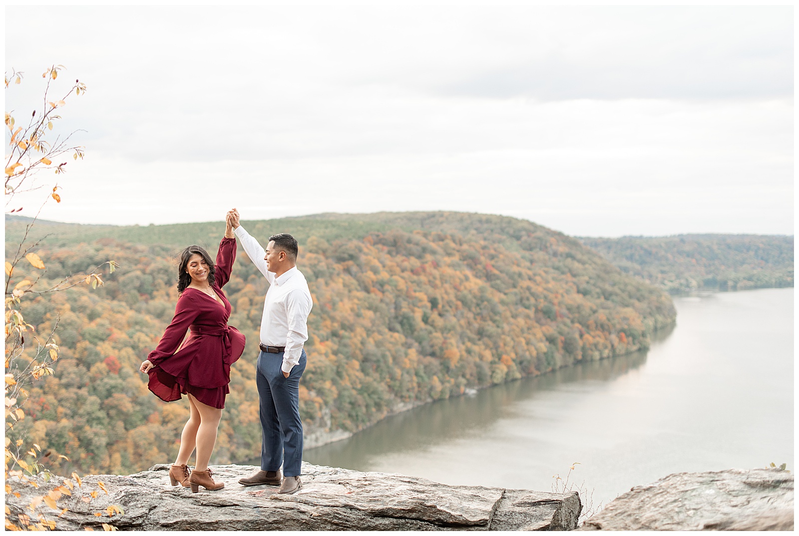 engaged couple atop pinnacle overlook as guy twirls girl under his right hand in holtwood pennsylvania