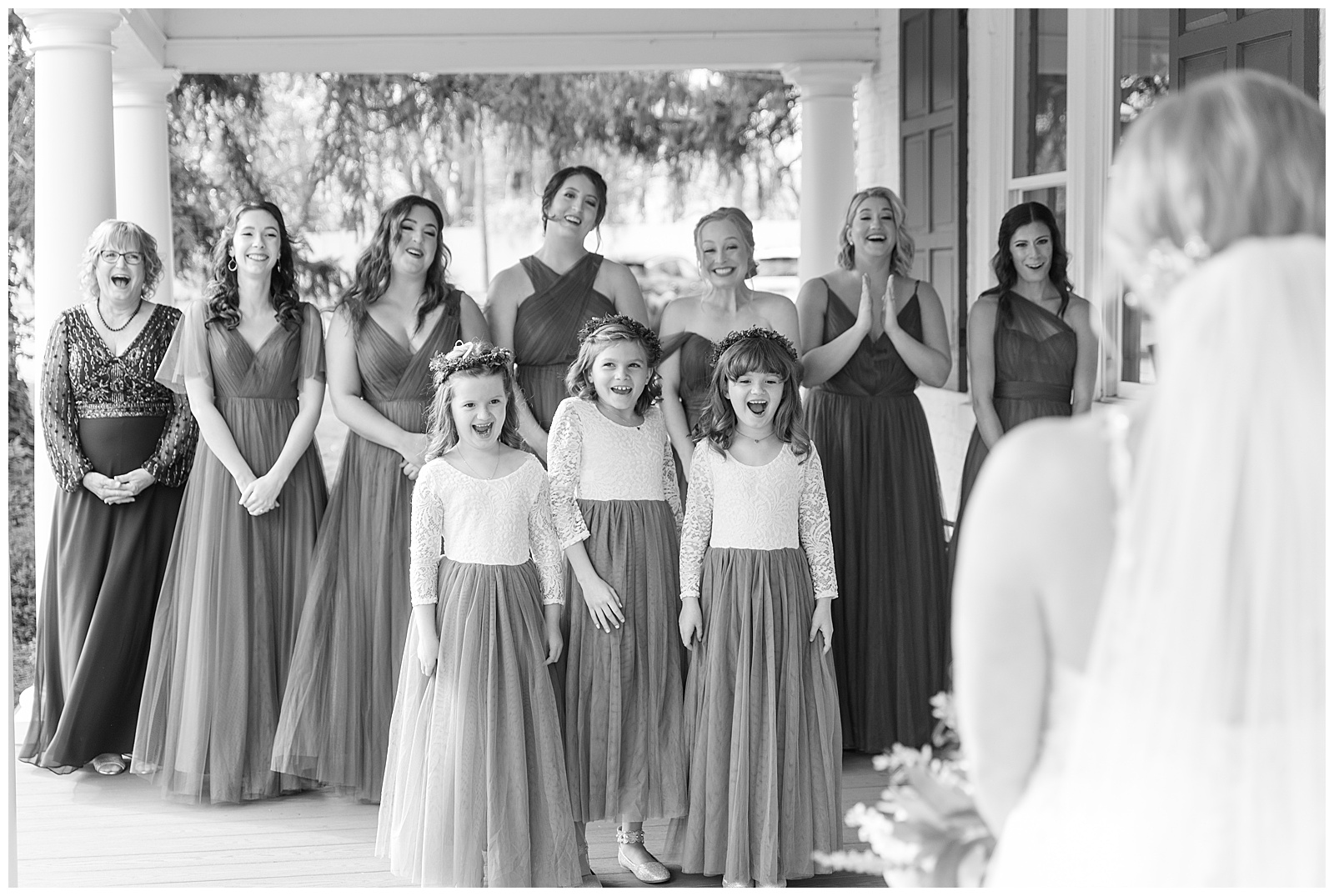 black and white photo of bridesmaids and flower girls reacting with joy to first look with bride at historic ashland