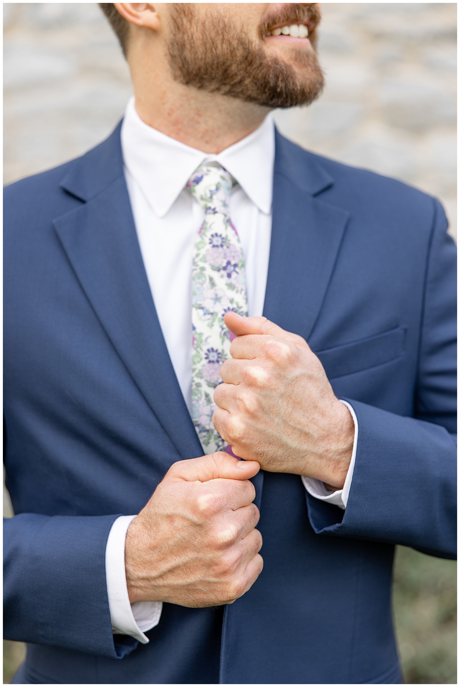 closeup photo of groom holding edges of his navy blue suit coat with a tight grip at historic ashland