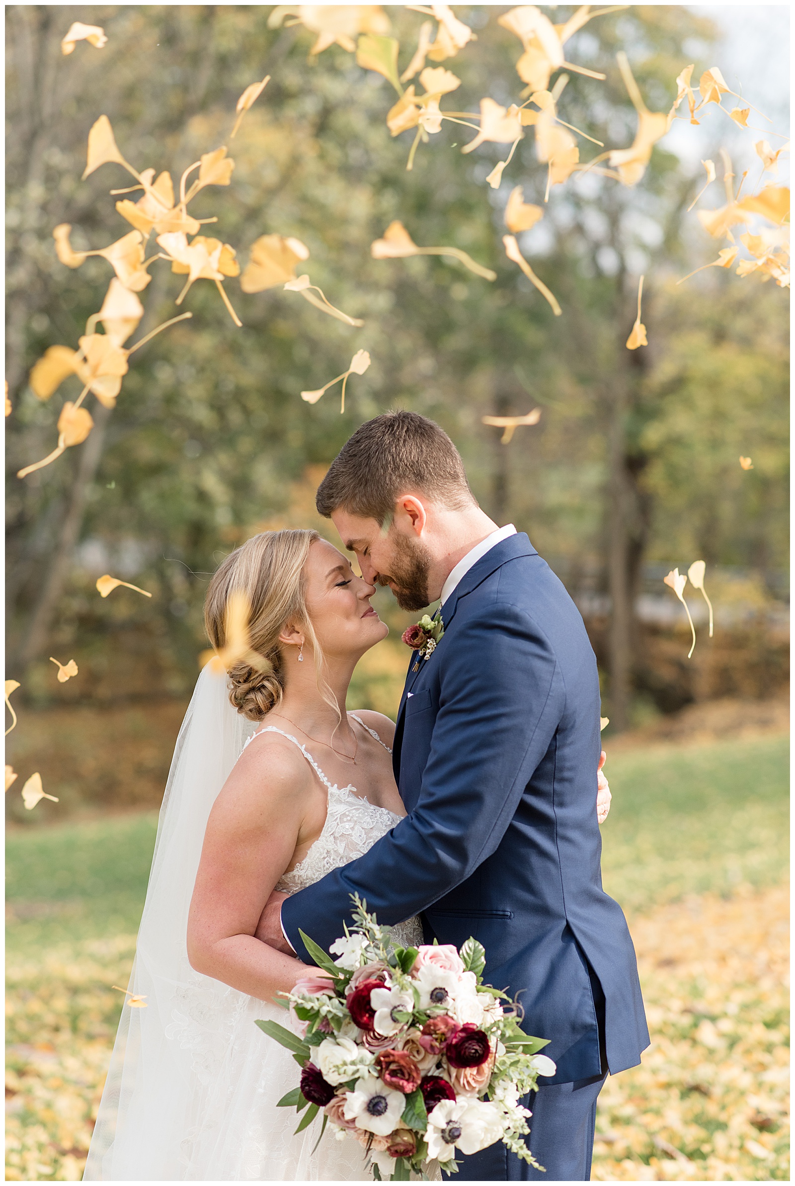 groom resting his forehead down on bride's forehead on fall day with colorful tree leaves in york county pennsylvania