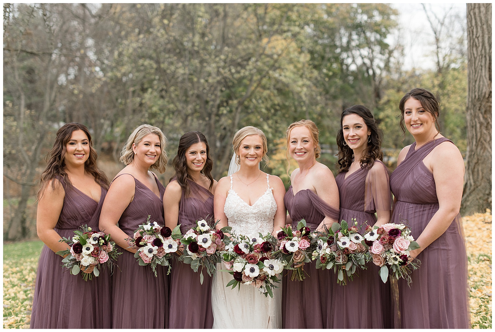 bride standing in middle of her six bridesmaids in a row all wearing trendy earthy brown gowns at historic ashland