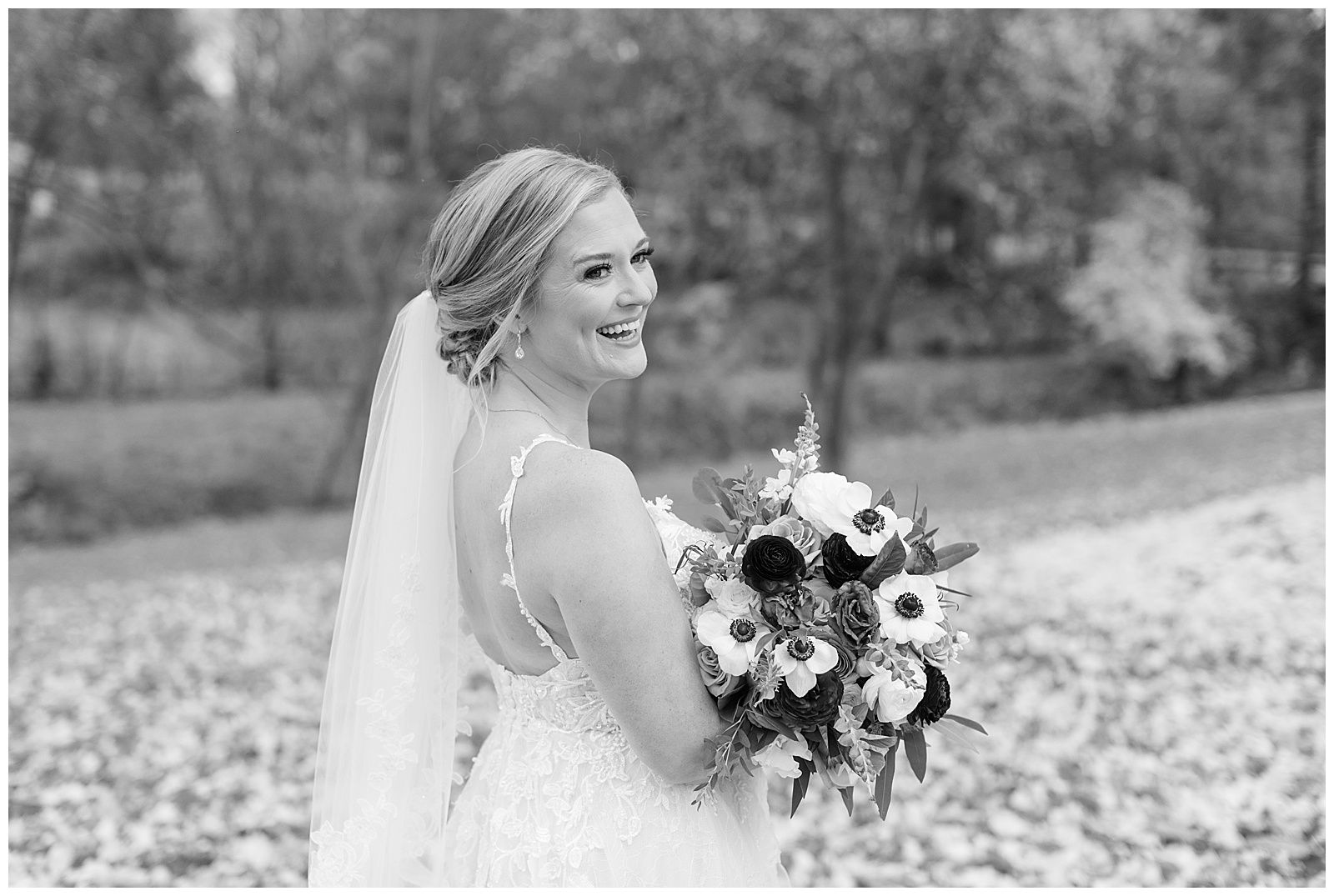 black and white photo of bride looking off over right shoulder holding beautiful bouquet of flowers at historic ashland in york pennsylvania
