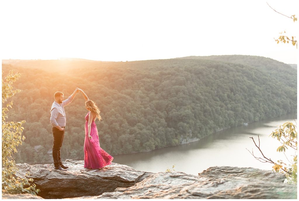 guy twirling girl under his left arm at sunset on large rock overlooking susquehanna river at pinnacle point overlook