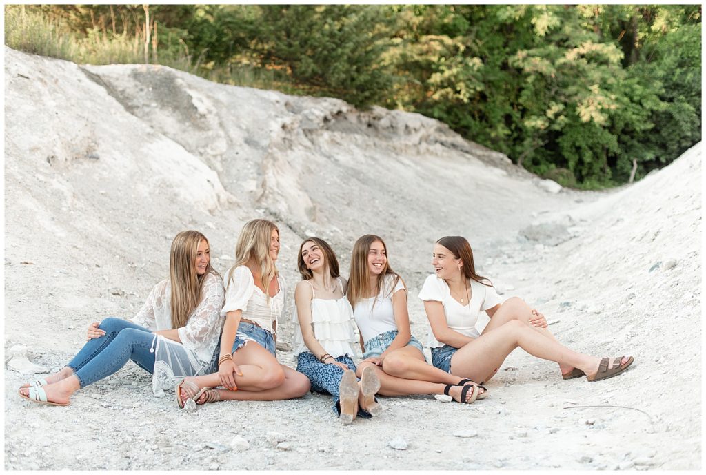 five senior girls all sitting and smiling and looking at each other on the white cliffs of conoy in lancaster county