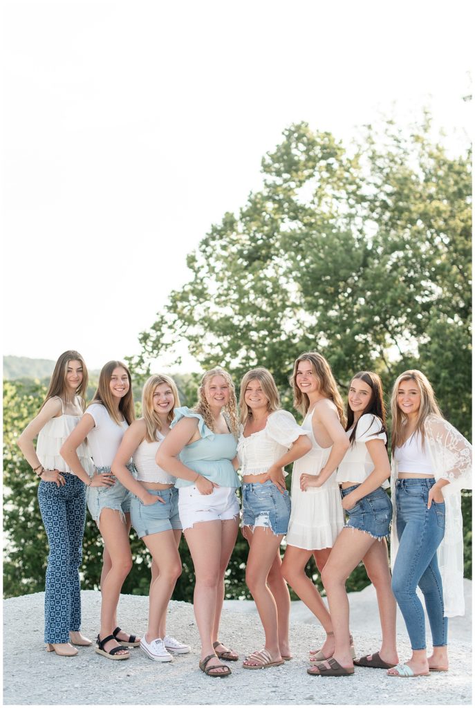 eight senior spokesmodel girls wearing blue jeans and white tops with hands on hips on sunny day at the white cliffs of conoy